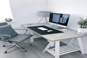 Aufgeräumter Entwickler-Arbeitsplatz mit Laptop und Code – ForgedSite entwickelt Ihre Website sauber, strukturiert und handwerklich professionell.